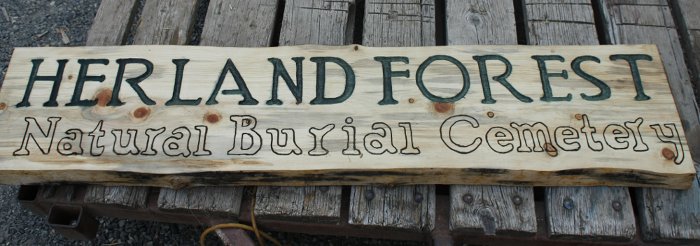 A sign carved by Andrew on wood from Windward's forest for our natural burial project, Herland Forest