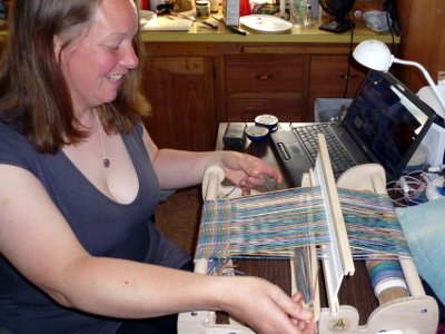 Opalyn weaving on a table loom